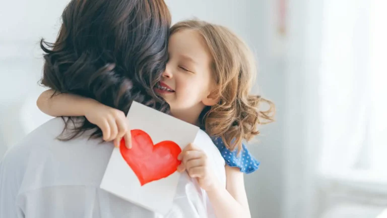 filha abraçando sua mãe segurando um cartão de dia das mães