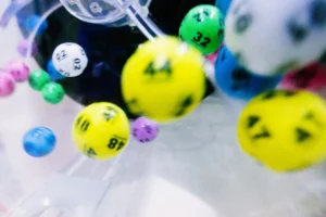 Bolas coloridas em movimento dentro de um globo de sorteio, representando o processo de sorteios e promoções comerciais regulamentadas.