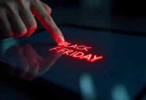 Dedo tocando uma tela digital que exibe em vermelho brilhante as palavras "Black Friday"
